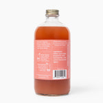 Clear glass bottle with a red liquid label on a white background. Available at Be Chamred