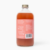 Clear glass bottle with a red liquid label on a white background. Available at Be Chamred