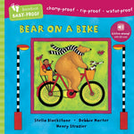 Book cover of 'Bear on a Bike' with colorful illustration of a bear riding a bike. Available at Be Charmed