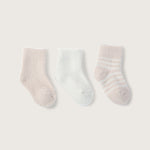 Three infant socks laid out flat, with two solid color socks in pink and pearl, and one striped sock in pink and pearl colors. Available at Be Charmed