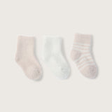 Three infant socks laid out flat, with two solid color socks in pink and pearl, and one striped sock in pink and pearl colors. Available at Be Charmed