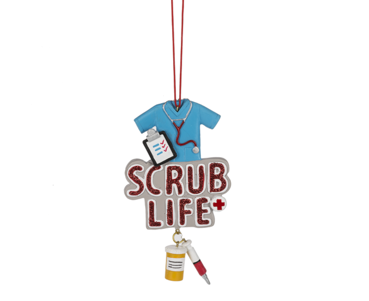 A Ganz "Scrub Life" Christmas ornament featuring detailed resin medical scrubs, a stethoscope, and a medical chart.