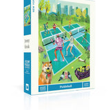 New York Puzzle Co Pickleball 500 piece jigsaw puzzle featuring a vibrant city park illustration by Jenny Kroik available at Be Charmed