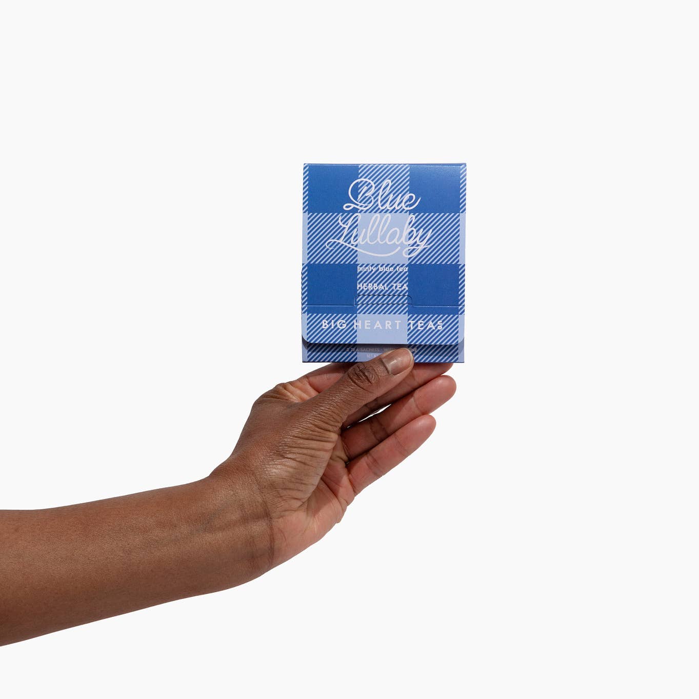 Hand holding a pack of Blue Lollys tea against a white background. Available at Be Charmed