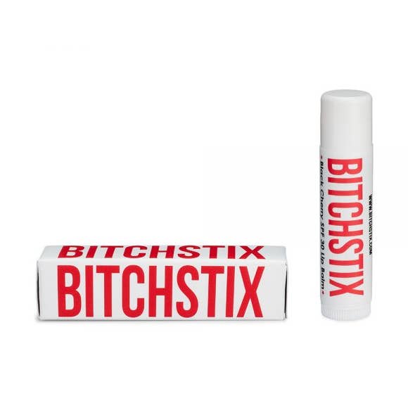 Black Cherry Bitchstix lip balm and packaging on a white background. Available at Be Charmed