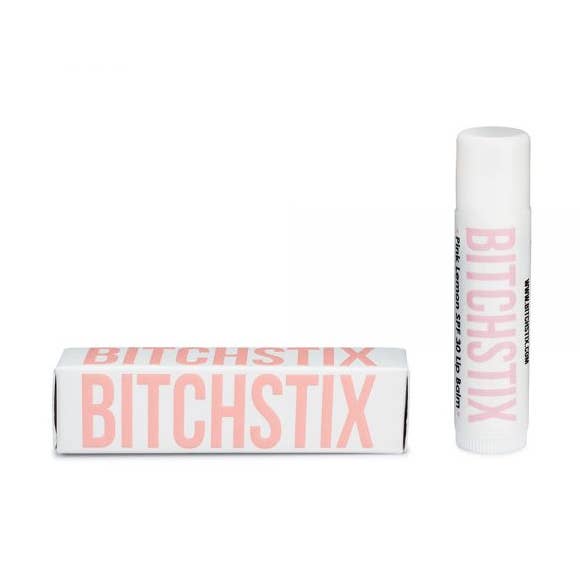 Pink Lemon Bitchstix lip balm and packaging on a white background. Available at Be Charmed