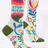 Colorful socks with floral designs and text on a light green background. Available at Be Charmed