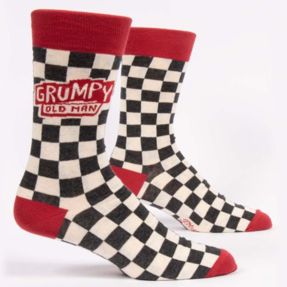 A pair of men's crew socks with a checkered pattern, featuring the text 'GRUMPY OLD MAN' on the ankle area. Available at Be Charmed