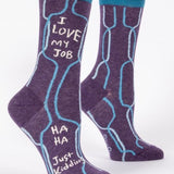 A pair of purple crew socks with blue q branding and the text 'I love my job' printed on the side, displayed against a white background. Available at Be Charmed