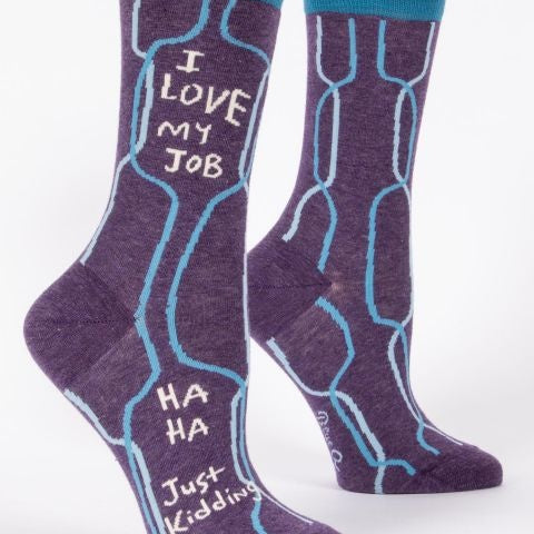 A pair of purple crew socks with blue q branding and the text 'I love my job' printed on the side, displayed against a white background. Available at Be Charmed
