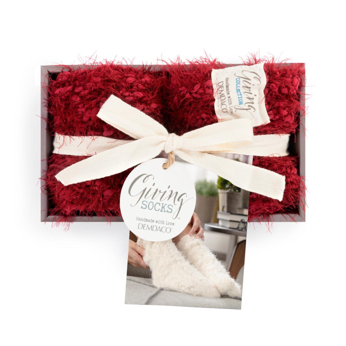 Boxed Red fuzzy socks with a white bow and 'Giving Socks' tag on a white background. Available at Be Charmed