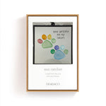 Coxed suncatcher with colorful paw prints and text on a white background. Available at Be Charmed