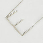 E Silver Initial Necklace by CAI, 16" chain with 2" extension, featuring a sleek silver-plated initial pendant, available at Be Charmed.