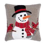A festive winter accent pillow featuring a smiling snowman surrounded by vibrant red winter cardinals in detailed hooked yarn, available at Be Charmed.