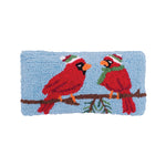 A festive winter accent cushion featuring crimson winter cardinals perched on a holiday branch in detailed hooked yarn, available at Be Charmed.