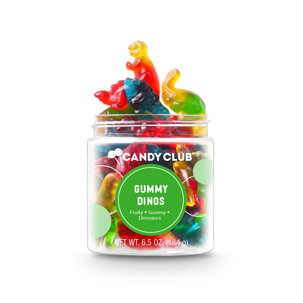 A clear plastic jar filled with colorful gummy candies shaped like dinosaurs, with the label 'Candy Club Gummy Dinosaurs' and net weight indicated as 5.6 oz (150 g). Available at Be Charmed. 