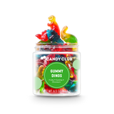 A clear plastic jar filled with colorful gummy candies shaped like dinosaurs, with the label 'Candy Club Gummy Dinosaurs' and net weight indicated as 5.6 oz (150 g). Available at Be Charmed. 