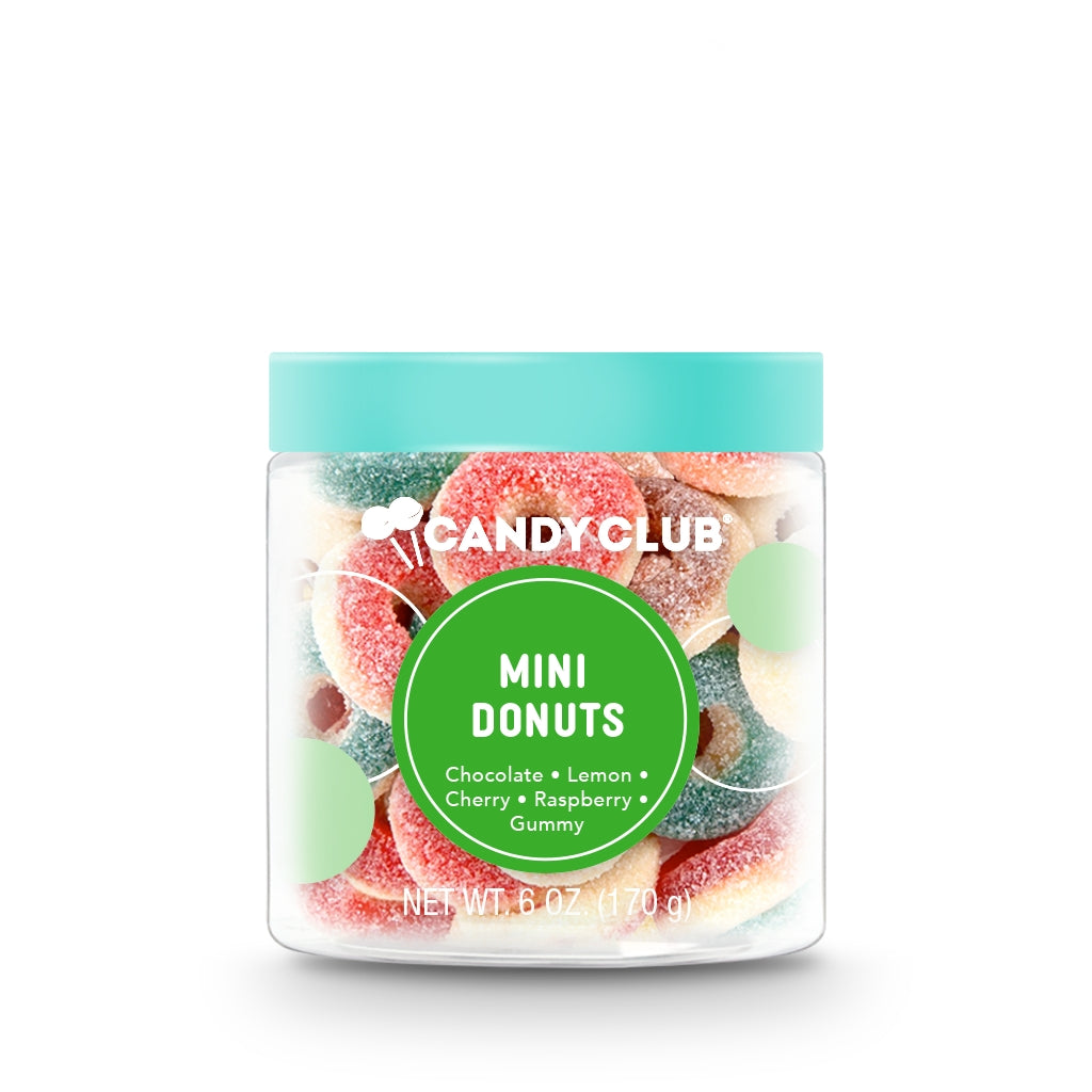 Mini Donuts by Candy Club—bite‑sized gummy donuts in chocolate, cherry, lemon, raspberry & cream flavors, sugar‑coated and colorful, available at Be Charmed.
