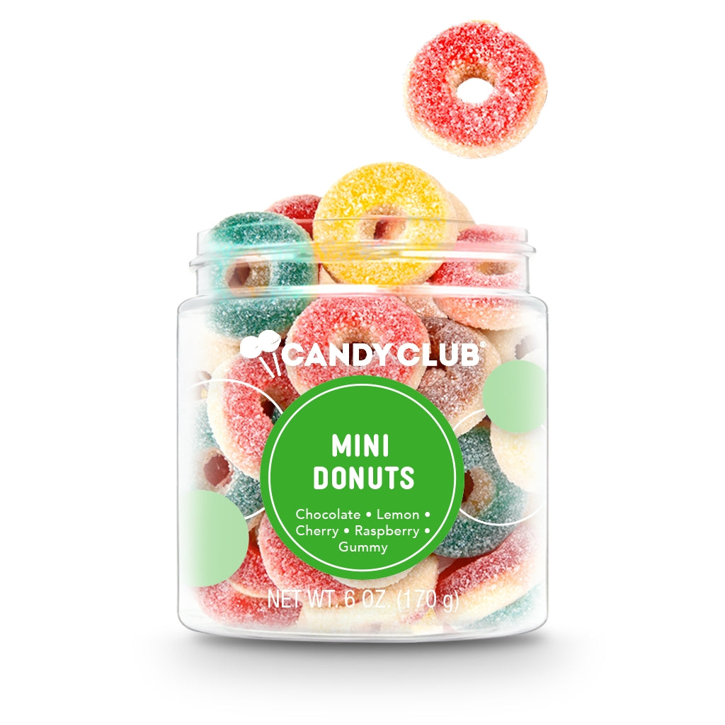 Opened Mini Donuts by Candy Club—bite‑sized gummy donuts in chocolate, cherry, lemon, raspberry & cream flavors, sugar‑coated and colorful, available at Be Charmed.
