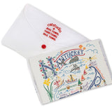 Folded with packaging Catstudio Nantucket dish towel featuring hand-illustrated island icons and coastal details, decorative and functional kitchen linen celebrating island pride, Available at Be Charmed
