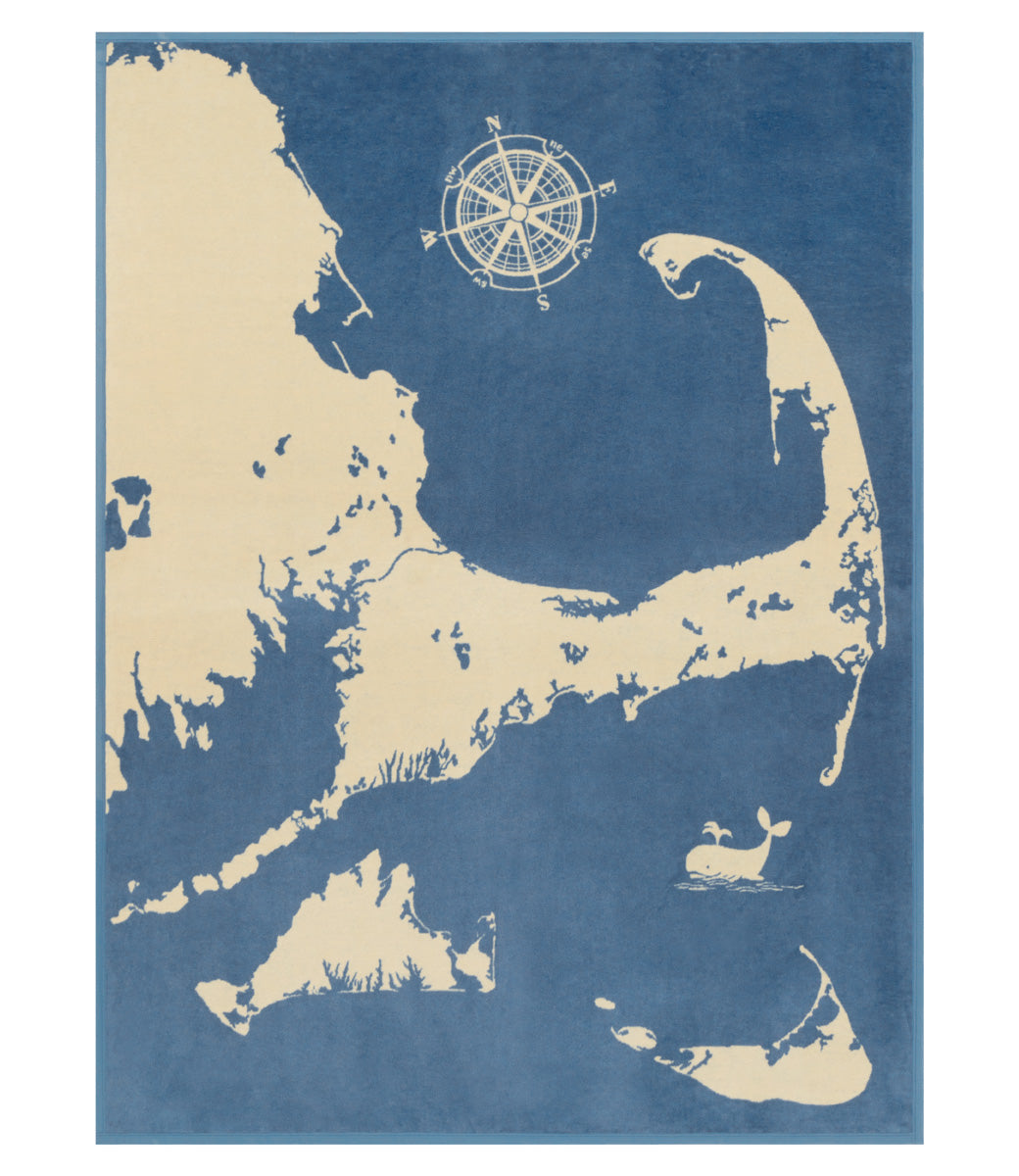 ChappyWrap Cape and Islands Map Blanket with a detailed illustration of Cape Cod, Martha’s Vineyard, and Nantucket in calming ocean hues. Crafted in a soft, durable cotton blend—ideal for beach homes or New England lovers. Available at Be Charmed.