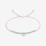 Pink bracelet with silver beads and heart charm on a white background. Available at Be Charmed