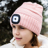 Pink knit beanie with a built-in light on a child outdoors. Available at Be Charmed