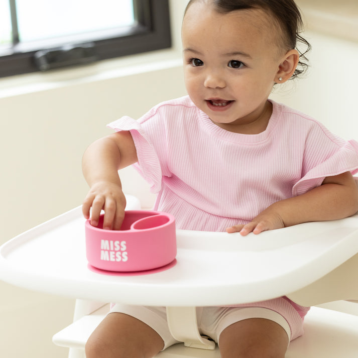 Child with Bella Tunno Miss Mess Wonder Bowl in pink, featuring a suction base and curved lip, available at Be Charmed.