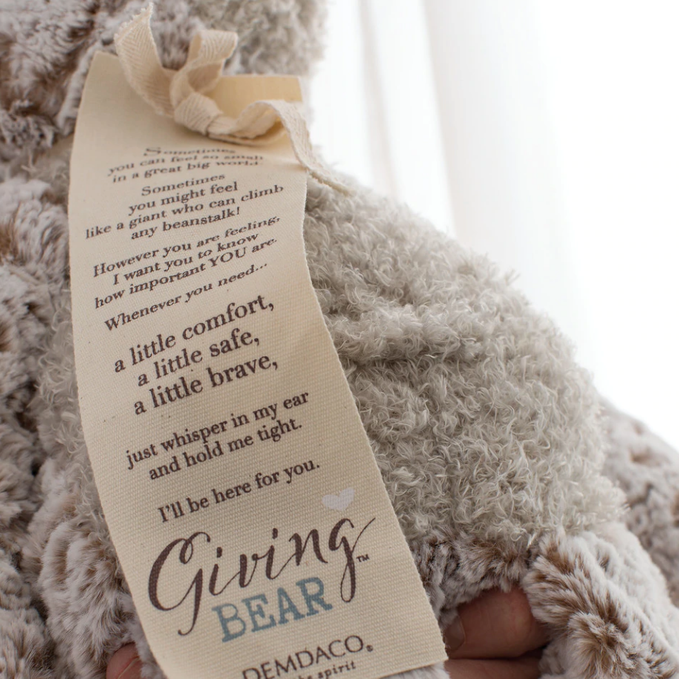 Demdaco Giving Bear plush toy in soft brown fur with close up picture of stitched message tag, available at Be Charmed. 