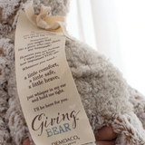 Demdaco Giving Bear plush toy in soft brown fur with close up picture of stitched message tag, available at Be Charmed.