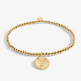 Gold beaded bracelet with a heart-shaped charm on a white background. Available at Be Charmed