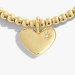 Gold beaded bracelet with a heart-shaped pendant featuring a diamond on a white background. Available at Be Charmed