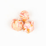 Close up of  Poppy Handcrafted Popcorn with a pink and white color scheme and floral patterns, labeled Cotton Candy. Available at Be Charmed