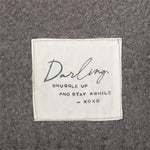 Close up picture of the tag on Demdaco Dear You Blanket – Darling, 50"x60" soft polyester throw with fringe and heartfelt message. Available at Be Charmed