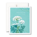 Greeting card with white flowers and green leaves on a blue background, featuring a quote by Ernest Holmes. Available at Be Charmed