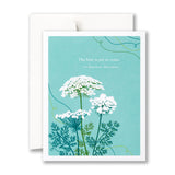 Greeting card with white flowers and green leaves on a blue background, featuring a quote by Ernest Holmes. Available at Be Charmed