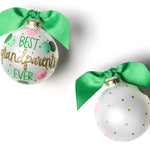 Two round glass ornaments with a green and pink polka dot design and gold glitter, finished with green ribbons. Available at Be Charmed