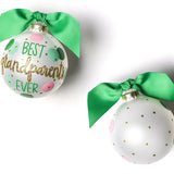 Two round glass ornaments with a green and pink polka dot design and gold glitter, finished with green ribbons. Available at Be Charmed