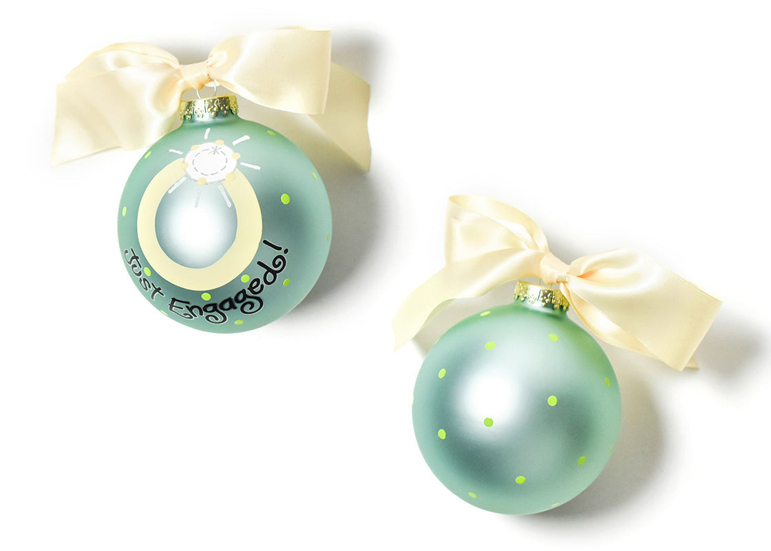 Two round glass ornaments with a hand-illustrated engagement ring and yellow ribbons for decoration. Available at Be Charmed