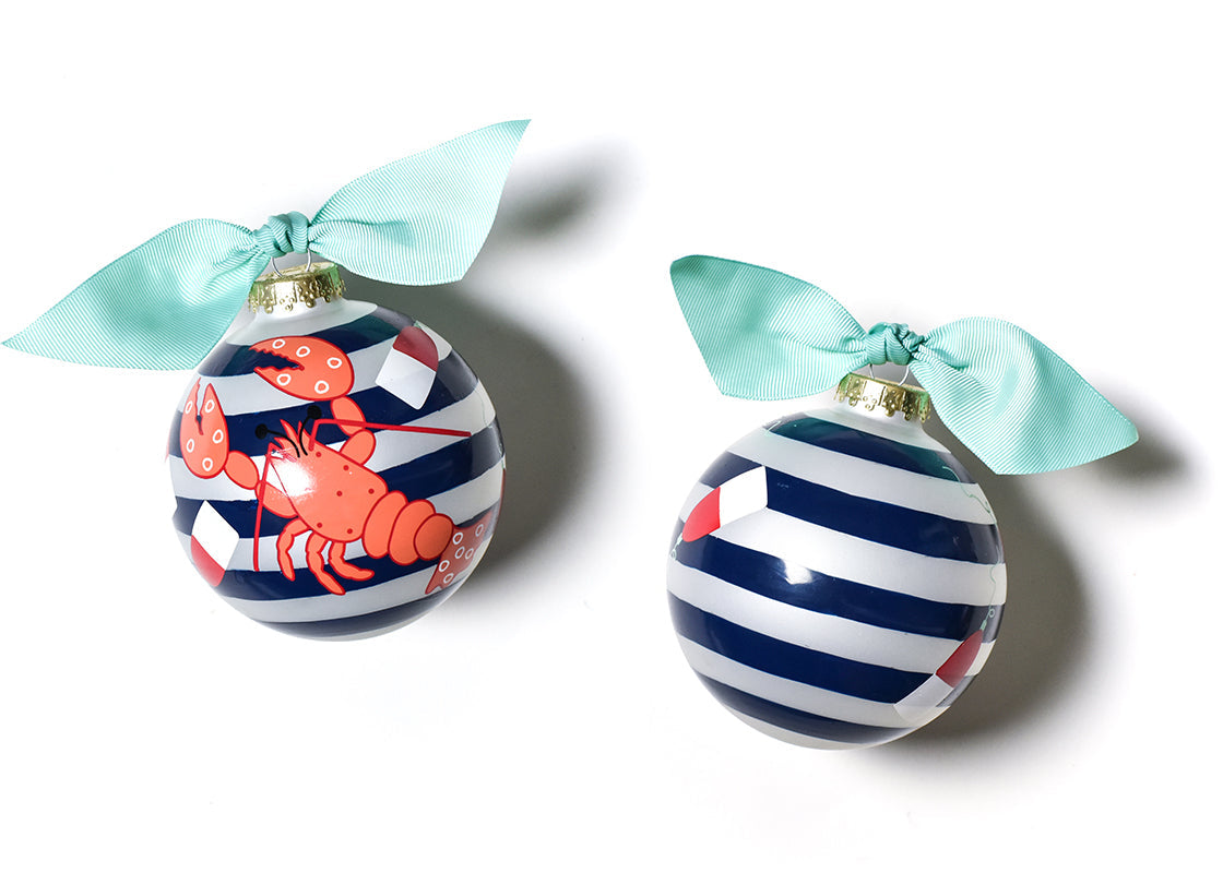 Two Christmas ornaments with striped patterns and lobster designs, tied with light blue ribbons on a white background. Available at Be Charmed
