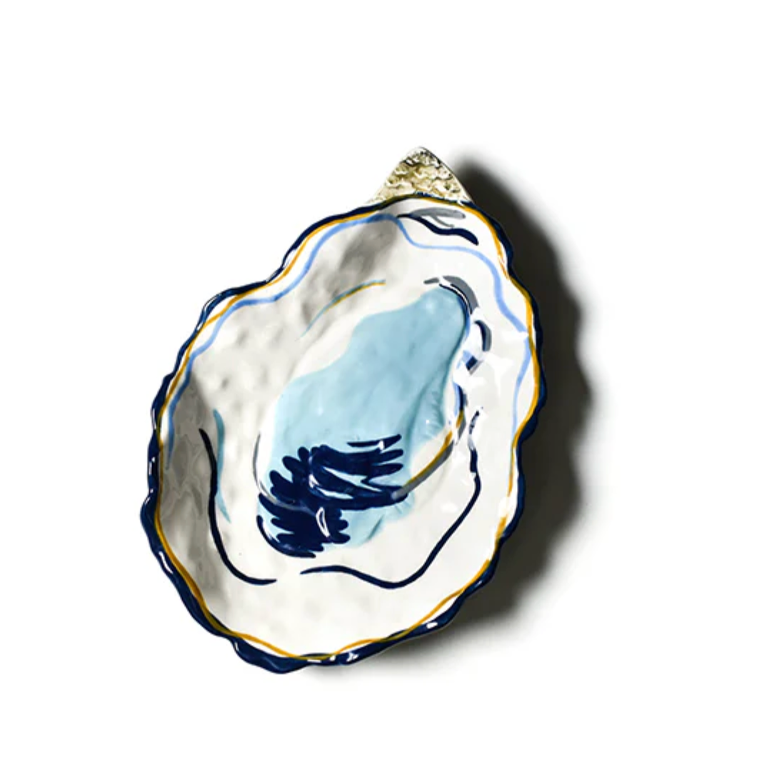 Hand‑painted Coton Colors oyster‑shaped ceramic plate with blue shell interior, gold accents, ideal for seafood or décor – Available at Be Charmed