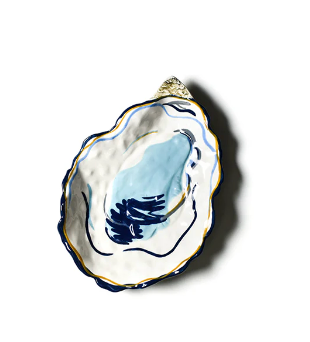 Hand‑painted Coton Colors oyster‑shaped ceramic plate with blue shell interior, gold accents, ideal for seafood or décor – Available at Be Charmed