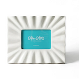 Coton Colors Signature White Ruffle Rectangle Frame – White stoneware frame with ruffled edge, holding a 4" x 6" photo, available at Be Charmed.