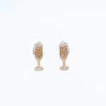 A pair of gold-colored hypoallergenic stainless steel post earrings featuring champagne pearls. Available at Be Charmed