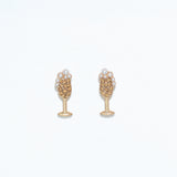A pair of gold-colored hypoallergenic stainless steel post earrings featuring champagne pearls. Available at Be Charmed
