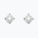 Pair of pearl earrings in silver setting on a white background. Available at Be Charmed