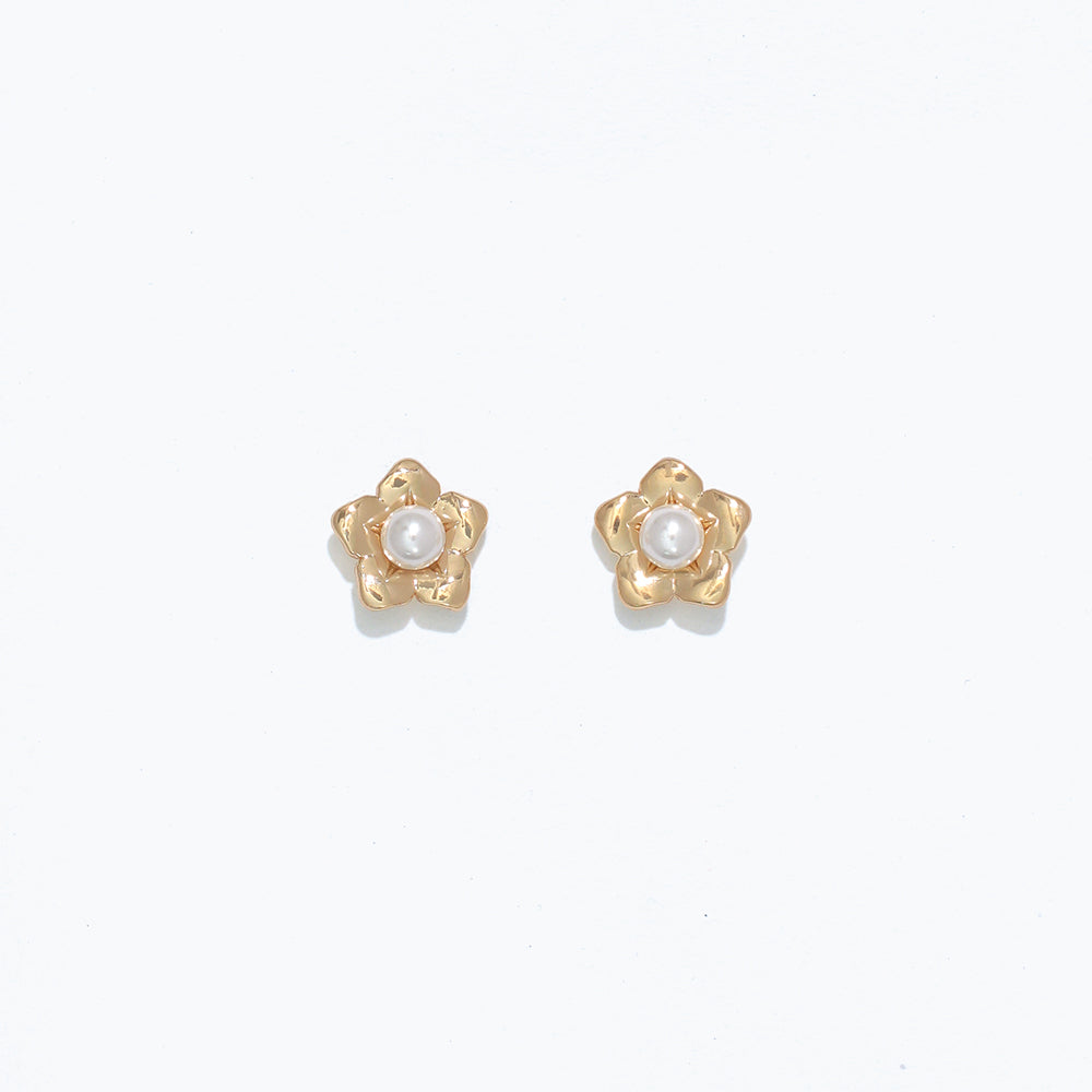 A pair of gold-colored floral earrings with pearl centers on a white background. Available at Be Charmed