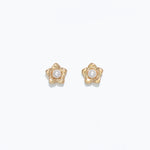 A pair of gold-colored floral earrings with pearl centers on a white background. Available at Be Charmed
