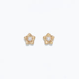 A pair of gold-colored floral earrings with pearl centers on a white background. Available at Be Charmed
