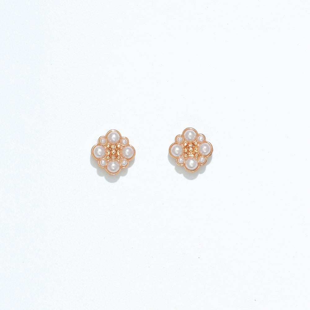 Cuties gold and pearl stud earrings with round faux pearls set in shiny gold-tone metal, designed for hypoallergenic wear. Timeless and elegant accessory for daily or special occasion use. Available at Be Charmed.